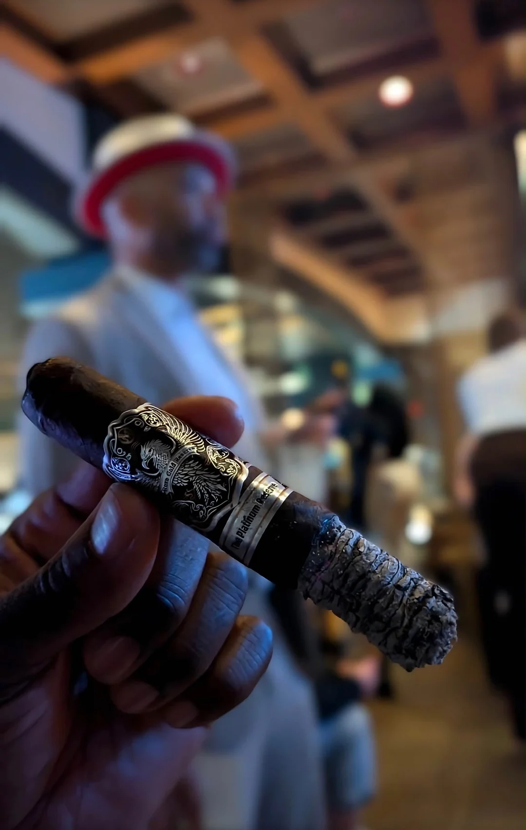 A Platinum Reserve cigar held up in a lounge