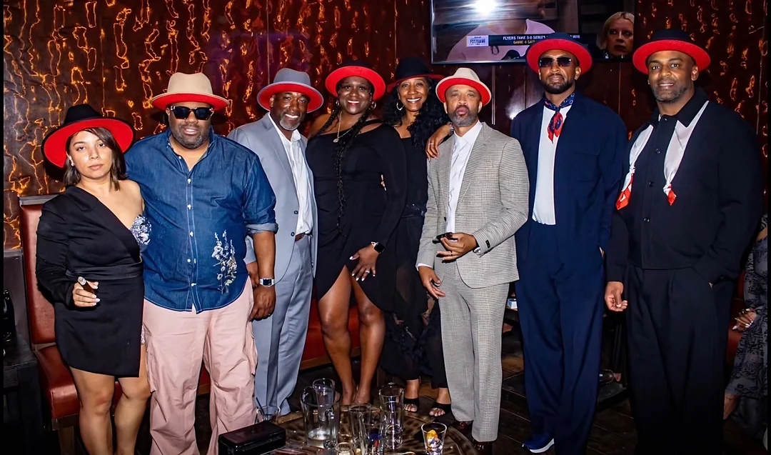 Friends of the Reserve in red-brim hats at a lounge evening
